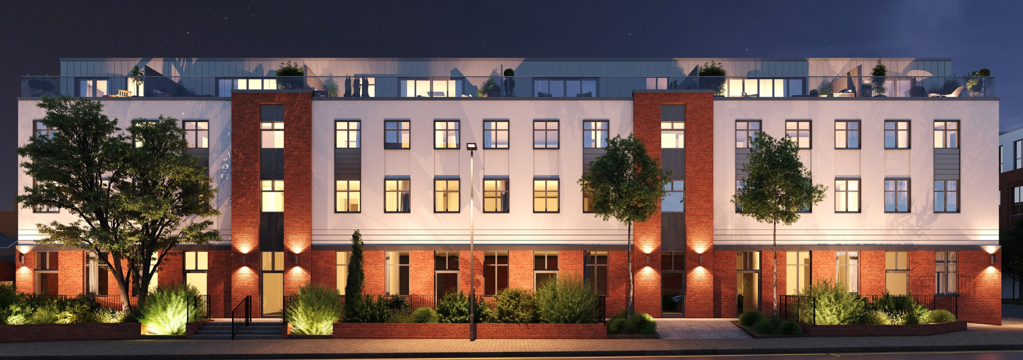 Sloane House apartment development illuminated at night, showing the full street elevation