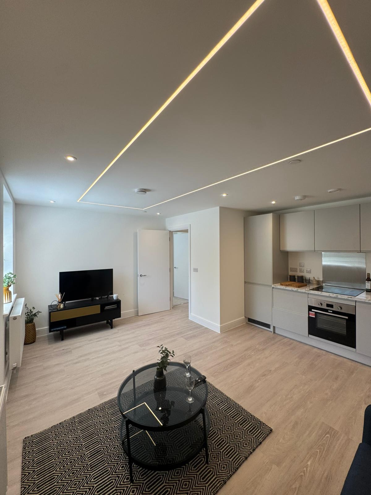 Finished open-plan apartment at Automotive House with feature LED ceiling lighting and a fitted kitchen