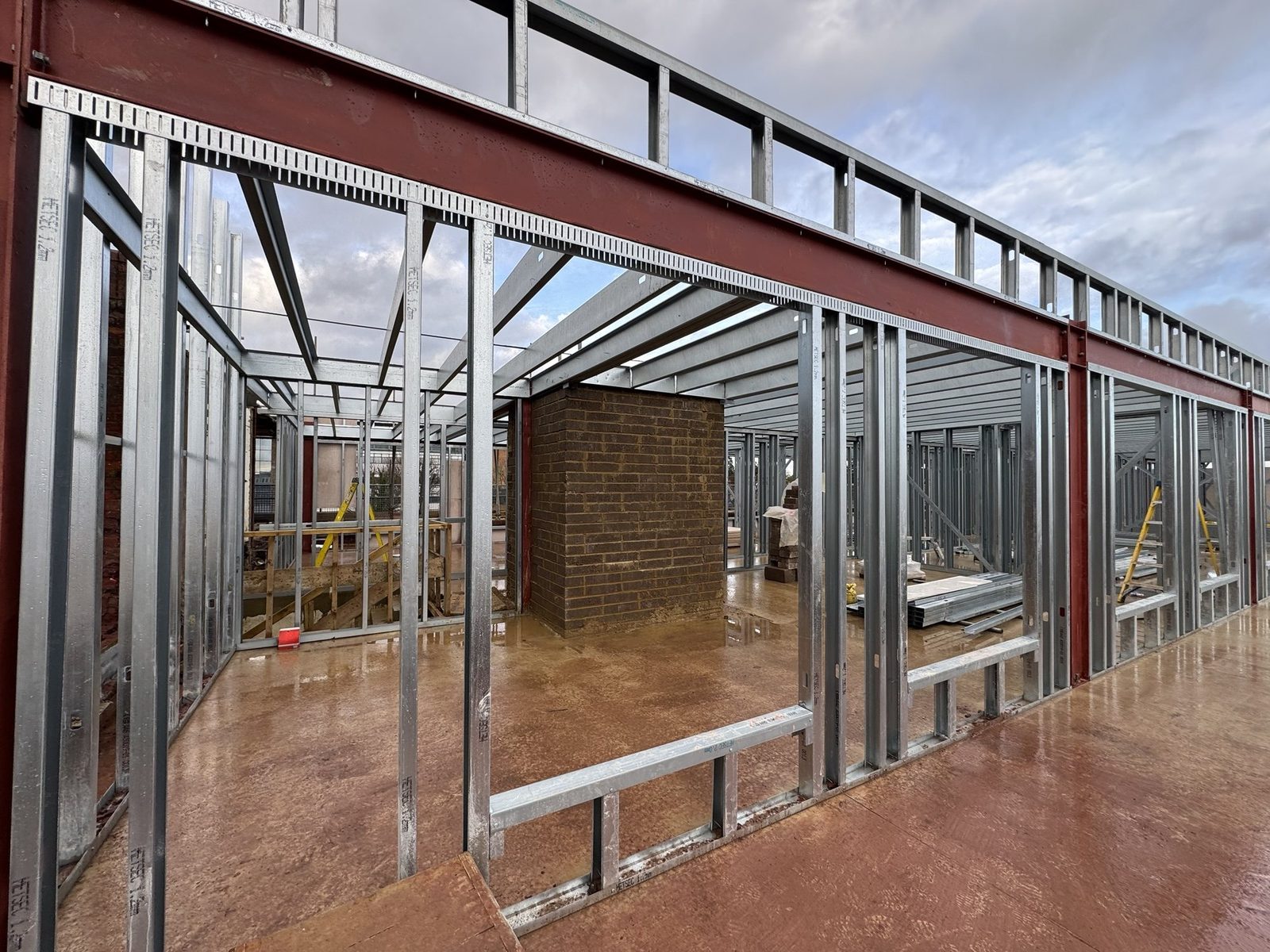 Red structural steel frame carrying a new top storey above the existing building at Tonman House, St Albans