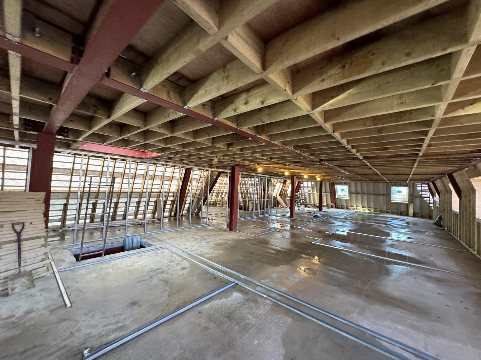 Red structural steel columns and beams carrying a new engineered timber floor at Automotive House